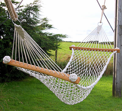 Hammock netted by hand in cotton with ash wood stays, in garden.