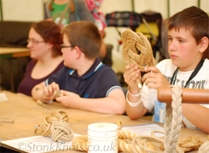 Learning a Turks Head thump mat and floating key ring at a knotting and ropes workshop, Wychwood 2012