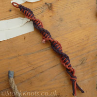 Finished spiral Half-Hitch Sennit bracelet in purple and orange cotton cord.